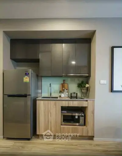 Modern compact kitchen with sleek cabinets and stainless steel appliances.