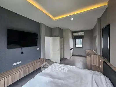 Modern bedroom with sleek design and large wall-mounted TV
