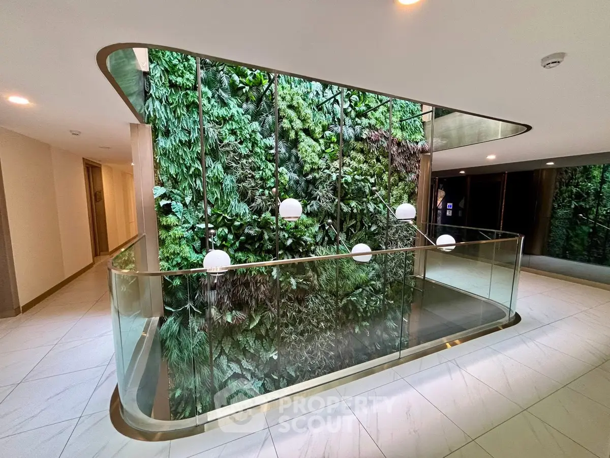 Luxurious building interior with stunning vertical garden and modern glass railing.