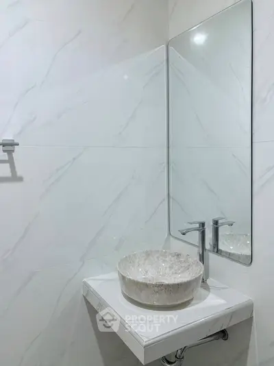 Modern minimalist bathroom with sleek marble sink and large mirror