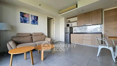 Modern open-layout living room with cozy sofa and sleek kitchen area