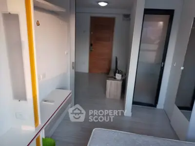 Modern bedroom with sleek design and wooden door, perfect for urban living.