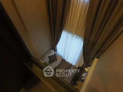 Luxurious high-ceiling living room with elegant curtains and cozy seating area.