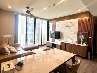 Luxurious modern living room with marble accents and large windows in high-rise apartment.