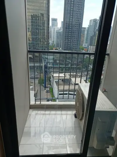 High-rise city view from a small balcony with air conditioning unit.