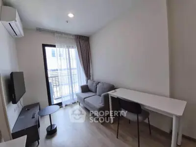 Modern living room with balcony access, featuring sleek furniture and natural light.