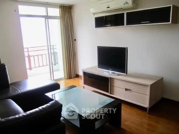 Modern living room with sleek furniture and balcony access in a stylish apartment.