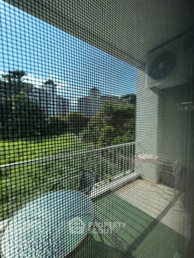 Charming balcony view with lush greenery and cityscape, perfect for relaxation and outdoor dining.