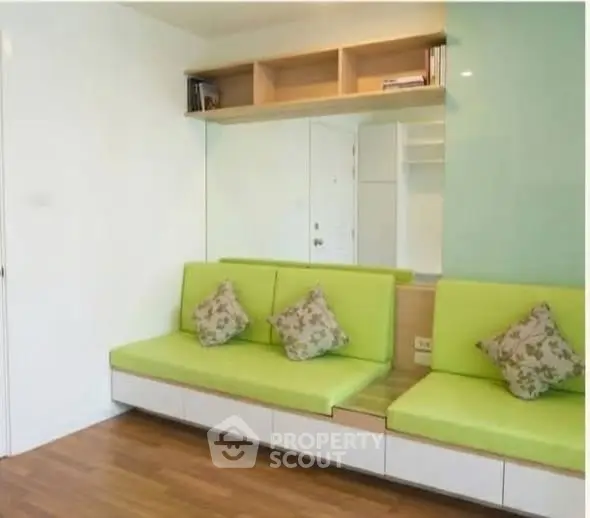 Modern living room with green seating and wooden flooring