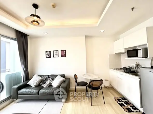 Modern living room with open kitchen, stylish decor, and natural light in a contemporary apartment.