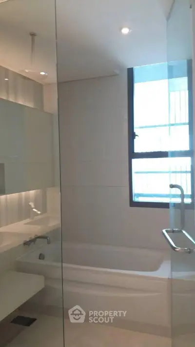 Modern bathroom with sleek design and large window for natural light.
