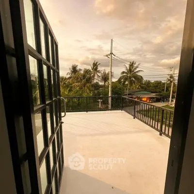 Spacious balcony with scenic view of lush greenery and palm trees, perfect for relaxation and outdoor enjoyment.