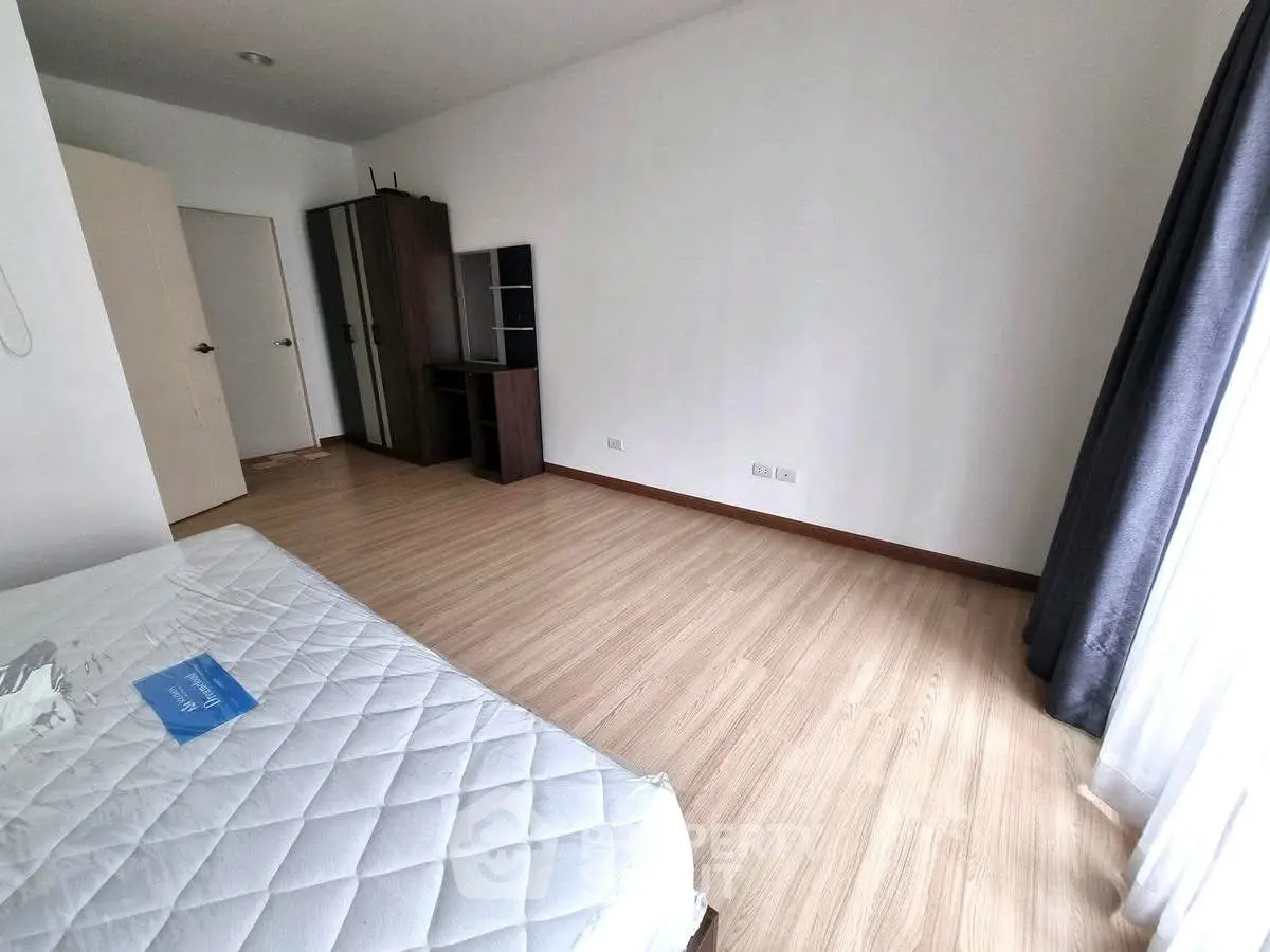Spacious bedroom with wooden flooring and natural light, perfect for a cozy retreat.