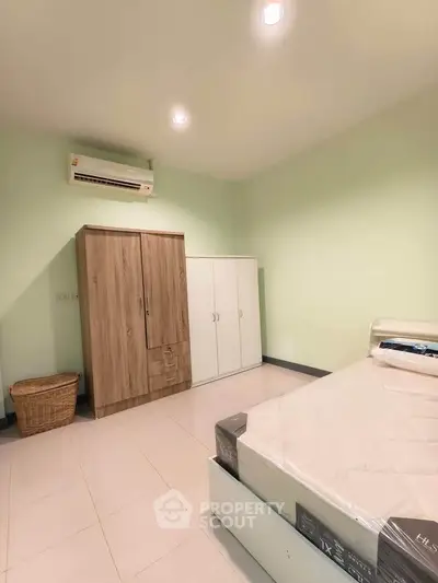 Spacious bedroom with modern furniture and air conditioning unit