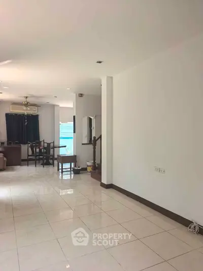 Spacious open-plan living room with modern decor and abundant natural light.