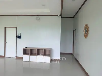 Spacious modern living room with minimalist decor and ample natural light.