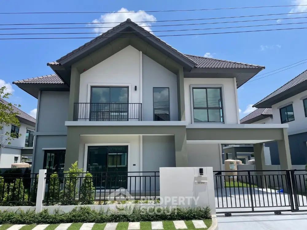 Modern two-story house with sleek design and spacious balcony in a serene neighborhood.