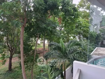 Stunning view from a modern balcony overlooking lush greenery and trees, perfect for nature lovers.