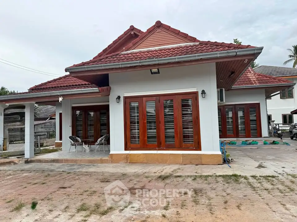 Charming single-story house with red tile roof and spacious patio, perfect for family living.