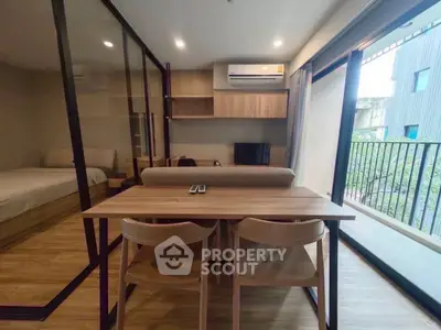 Modern apartment interior with open layout, featuring a cozy living area and balcony view.