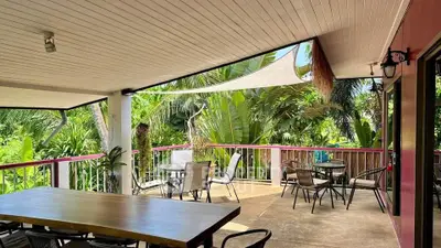 Spacious tropical balcony with lush greenery and outdoor seating area