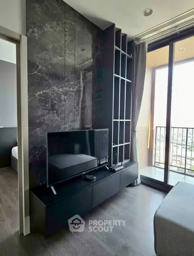 Modern living room with sleek TV setup and floor-to-ceiling windows offering stunning views.