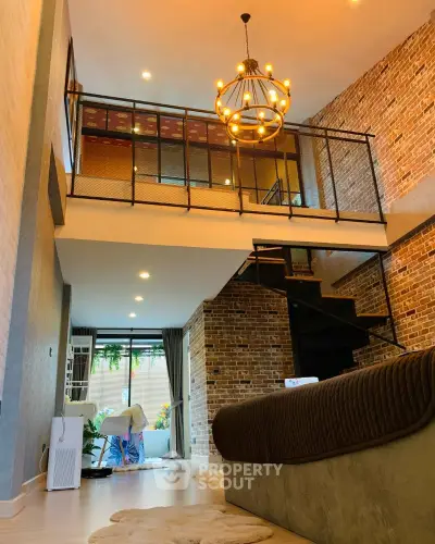 Stunning loft-style living room with exposed brick walls and modern chandelier