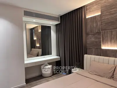 Modern bedroom with elegant decor and stylish lighting, featuring a cozy bed and a sleek vanity mirror.