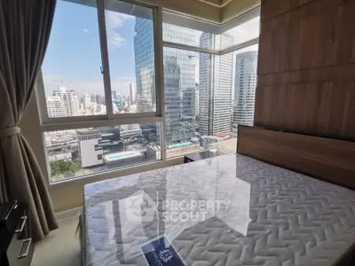 Modern bedroom with stunning city view and large windows in high-rise apartment.