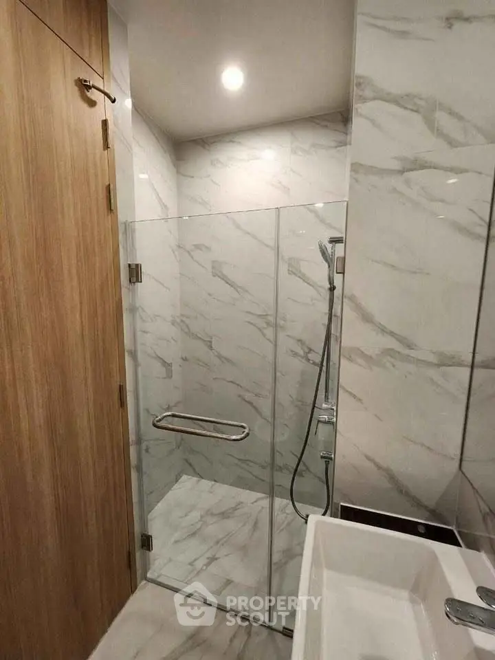 Modern bathroom with glass shower and marble tiles