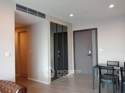 Modern living room with sleek dining area and mirrored closet doors