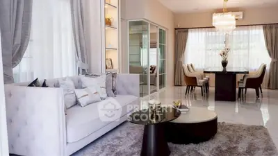 Luxurious living room with elegant decor and spacious dining area, featuring plush seating and modern lighting.