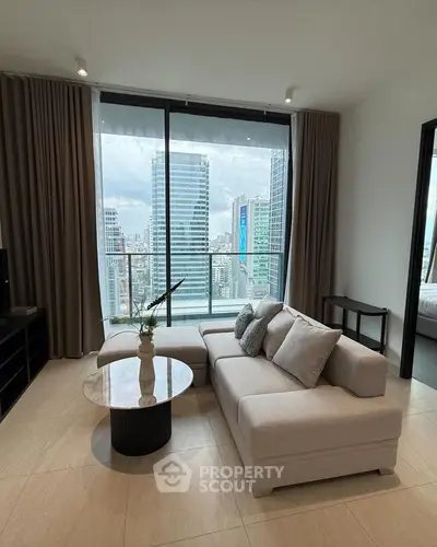 Modern living room with city view, featuring stylish sofa and elegant decor.
