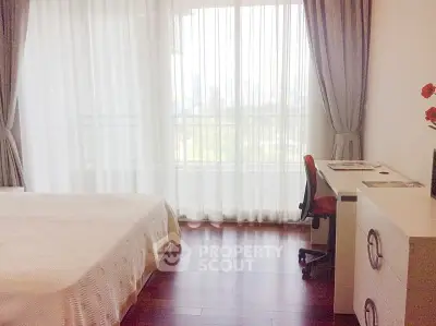Bright bedroom with large window and modern furnishings in a stylish apartment.