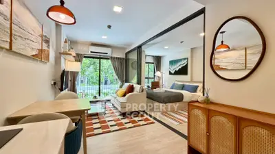 Modern open-plan living room and bedroom with stylish decor and large windows.