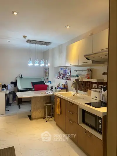 Modern kitchen with open layout and stylish lighting in cozy apartment.