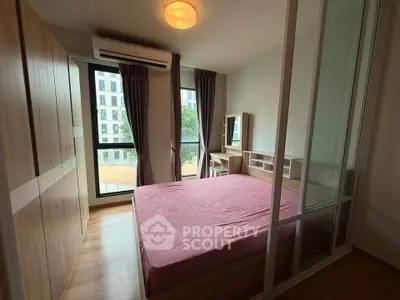 Modern bedroom with large windows and built-in wardrobe in a stylish apartment.
