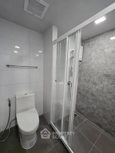 Modern bathroom with sleek shower and toilet in contemporary design.