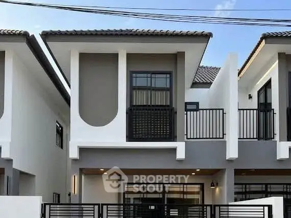 Modern two-story townhouse with sleek design and balcony, perfect for urban living.