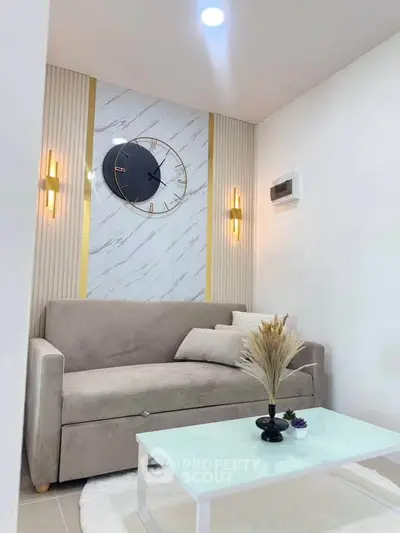 Modern living room with stylish decor, featuring a sleek sofa, elegant wall clock, and ambient lighting.