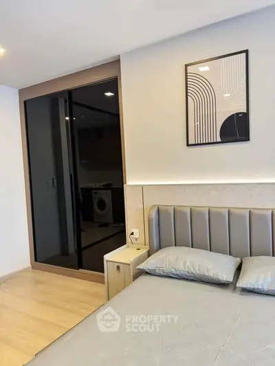 Modern bedroom with sleek design and stylish decor, featuring a comfortable bed and contemporary artwork.