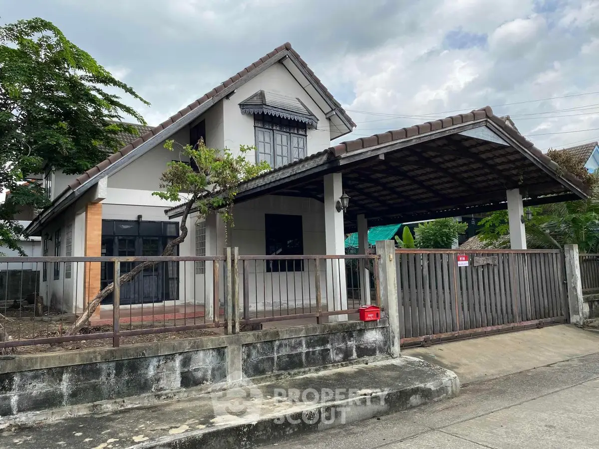 Charming two-story house with spacious carport and gated entrance in a serene neighborhood.