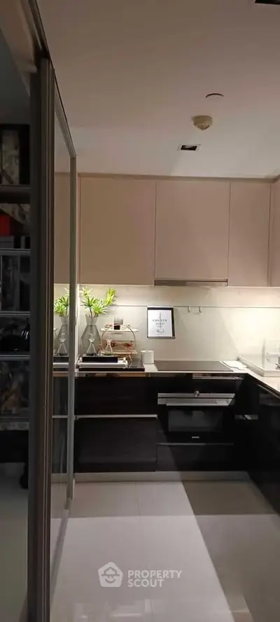 Modern kitchen with sleek cabinetry and built-in appliances, featuring a stylish open layout and elegant lighting.