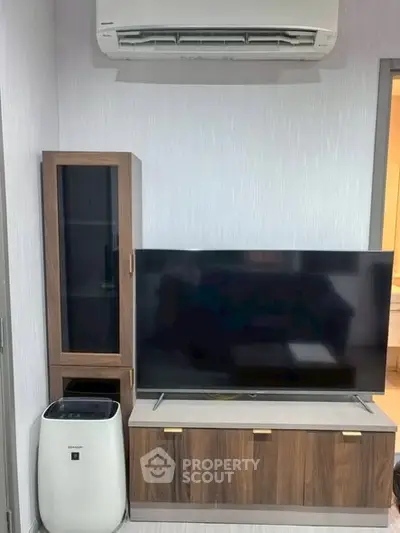Modern living room with sleek TV setup and air conditioning unit