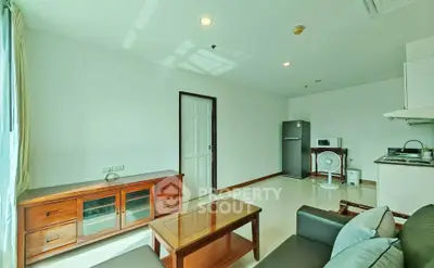 Bright and airy living room with modern furniture and kitchen area in open layout apartment.