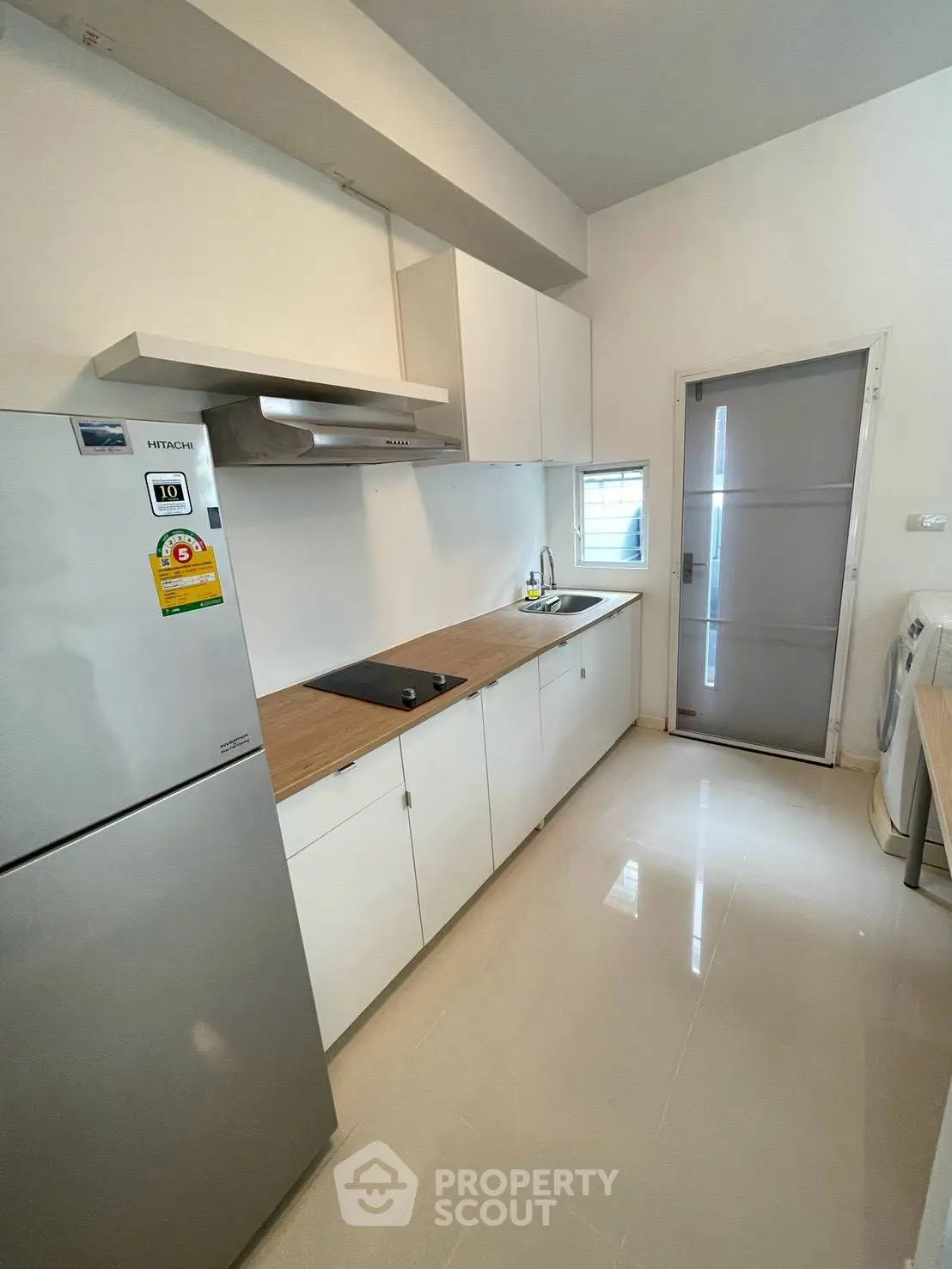 Modern kitchen with sleek white cabinets, stainless steel appliances, and a compact layout.