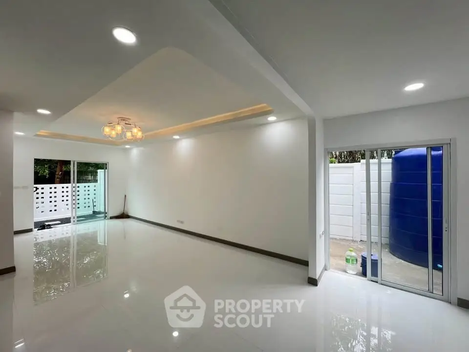 Spacious modern living room with sleek lighting and large windows for natural light.