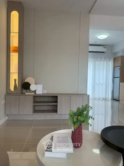 Modern living room with sleek furniture and elegant decor, featuring a stylish cabinet and ambient lighting.
