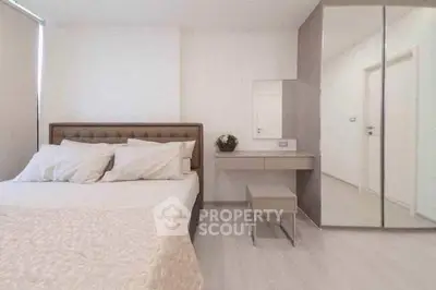 Modern bedroom with elegant decor and mirrored wardrobe in a stylish apartment.