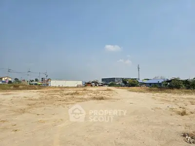 Expansive vacant land with development potential under clear blue sky.